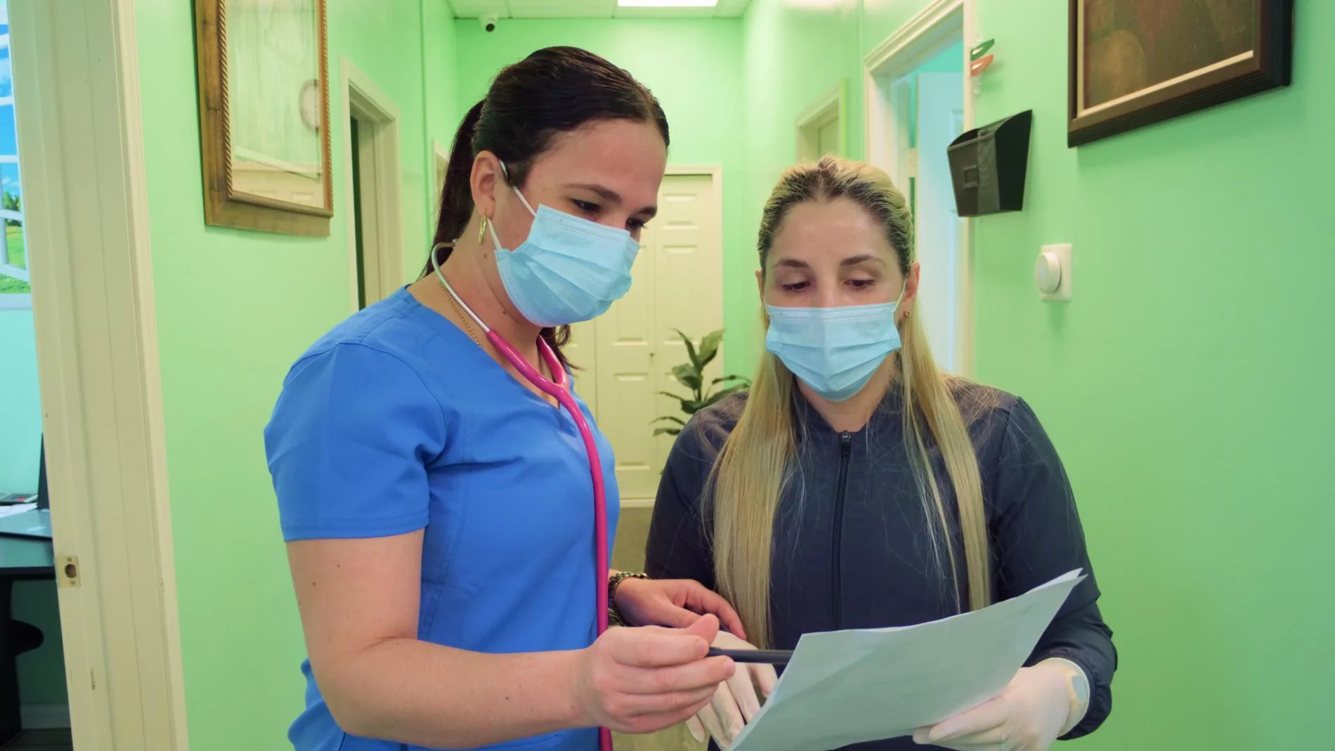Doctora hispana preparando material para realizar una sutura en un ambiente estéril.